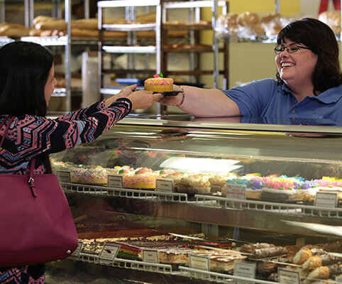 Susan handing cupcake to customer